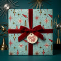 Retro space wrapping paper with rocket pattern and red velvet bow by Wrapped Studios.