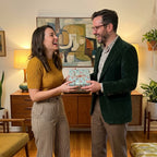 Retro mid-century modern wrapping paper on a gift held by a smiling couple. Wrapped Studios.