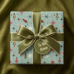 Retro space wrapping paper with a rocket ship print and green satin ribbon, by Wrapped Studios.