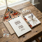 Western ranch wedding invitation with red truck envelope liner on rustic wood table by Wrapped Studios.