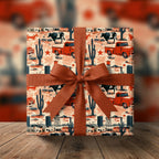 Western wrapping paper with vintage red trucks and cacti, tied with a rust bow by Wrapped Studios.