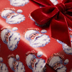Luxury vintage Santa Christmas gift wrap with a red velvet bow by Wrapped Studios.