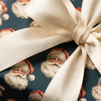 Vintage Santa Claus wrapping paper tied with a luxury cream satin ribbon by Wrapped Studios.