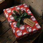 Vintage red Santa Christmas wrapping paper by Wrapped Studios on a gift with rustic green ribbon.