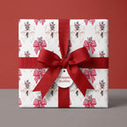 Christmas wrapping paper with red bow pattern, tied with a red ribbon on a gift box by Wrapped Studios.