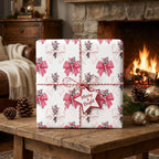 Cozy red bow holiday gift wrap on a present by a fireplace. Christmas wrapping paper by Wrapped Studios.