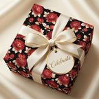 Luxury floral gift wrap with red roses on black, elegant cream bow, and gold Celebrate tag by Wrapped Studios.