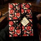 Luxury vintage floral wrapping paper with red roses and velvet bow by Wrapped Studios.