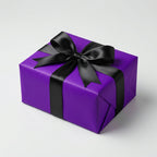 Square gift wrapped in purple paper with a black satin bow, perfect for birthday or holiday celebrations.
