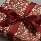 Elegant gift wrapped in floral wrapping paper with a luxurious burgundy ribbon bow.