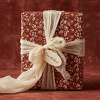 Elegant gift wrapped in red floral wrapping paper with ivory ribbon and "From the heart" tag.
