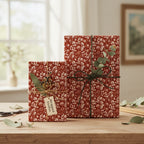 Elegant floral wrapping paper on gifts tied with twine and greenery, warm rustic style.