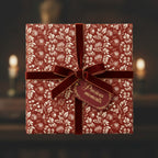 Elegant gift box wrapped in rustic floral wrapping paper with a velvet burgundy ribbon and "precious moments" tag.