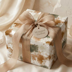 Modern abstract wrapping paper in sage green and terracotta with a champagne bow by Wrapped Studios.