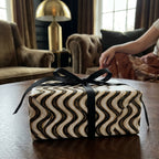 Luxury retro wrapping paper with black and gold waves and a black ribbon, by Wrapped Studios.