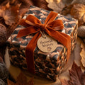 Autumn acorn wrapping paper with a burnt orange velvet bow and Harvest Wishes tag by Wrapped Studios.