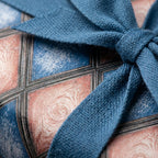Rustic blue and terracotta geometric wrapping paper with a woven blue ribbon by Wrapped Studios.