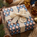 Blue and pink argyle wrapping paper with a burlap bow on a rustic holiday gift box by Wrapped Studios.