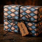 Vintage diamond wrapping paper in blue and peach on a rustic gift box with twine, from Wrapped Studios.