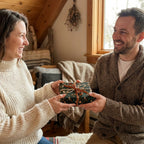 Couple exchanging a holiday gift in rustic green forest Christmas wrapping paper by Wrapped Studios.
