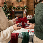 Luxury Christmas wrapping paper with red velvet bow on holiday gift held by a couple, Wrapped Studios.