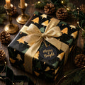 Elegant Christmas gift wrapped in Wrapped Studios tree print paper with gold ribbon and Merry & Bright tag.