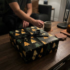 Black Christmas wrapping paper with gold/green trees and black ribbon by Wrapped Studios.