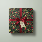 Square gift wrapped in floral Christmas wrapping paper with red ribbon and holly berry pattern.