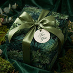Rustic forest Christmas wrapping paper with green pine needles, an olive satin bow, and "For You" gift tag.