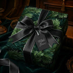 Luxury dark green pine Christmas wrapping paper with black satin ribbon, silver trim, and "With Love" gift tag.