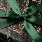 Luxury woodland deer Christmas gift wrap with an emerald green satin bow by Wrapped Studios.
