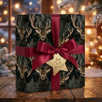 Rustic deer Christmas wrapping paper with a burgundy satin bow and gold star tag by Wrapped Studios.