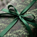 Luxury forest pine Christmas gift wrap tied with a green satin ribbon by Wrapped Studios.
