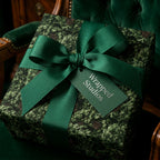 Luxury evergreen pine Christmas wrapping paper with green ribbon by Wrapped Studios.