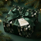 Luxury Christmas wrapping paper with a pine tree pattern and green satin bow by Wrapped Studios.