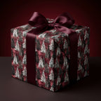 Luxury burgundy Christmas wrapping paper with a pine tree pattern and satin ribbon bow by Wrapped Studios.