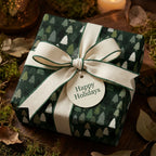 Rustic pine tree Christmas gift wrap with a cream ribbon and Happy Holidays tag by Wrapped Studios.