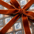 Luxury gift wrap in a vintage tile pattern with a rust velvet ribbon by Wrapped Studios.