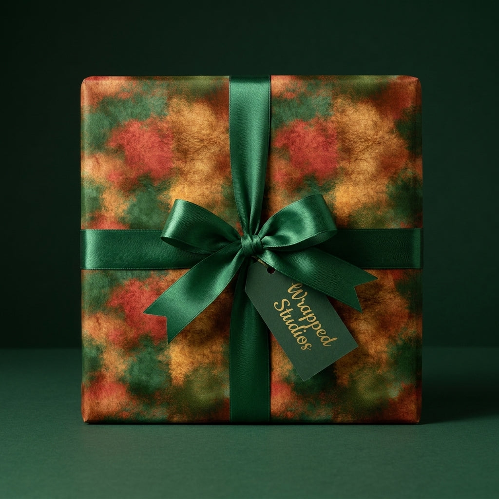 Luxury Christmas gift wrap in green and gold watercolor with a dark green satin bow by Wrapped Studios.