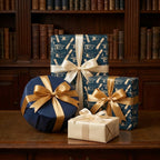 Navy blue graduation wrapping paper with cap and diploma patterns and gold bows by Wrapped Studios.
