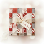 Romantic patchwork gift wrap with red heart and floral patterns, tied with an ivory ribbon and "To My Love" tag, perfect for Valentine's Day.