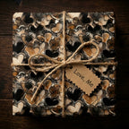 Abstract heart wrapping paper in neutral tones, tied with twine. "Love, Me" tag.