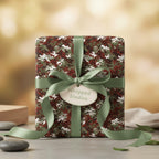 Modern gift box wrapped in camouflage print paper with sage green ribbon and tag.