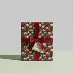Elegant gift wrapped in abstract floral wrapping paper with a red satin ribbon and "A Gift For You" tag.