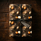 Rustic wrapping paper with bird nests, speckled eggs, dark bow, and 'HANDMADE' tag on wood. Wrapped Studios.