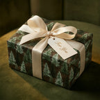Rustic pine tree Christmas wrapping paper with cream satin ribbon and gift tag, by Wrapped Studios.