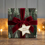 Luxury pine tree Christmas wrapping paper with a red velvet bow by Wrapped Studios.