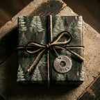 Rustic forest Christmas wrapping paper with evergreen trees and a twine bow by Wrapped Studios.