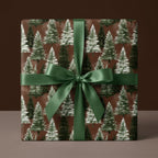 Rustic pine tree Christmas wrapping paper with a green satin ribbon bow, by Wrapped Studios.