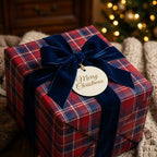 Red plaid Christmas wrapping paper with a navy velvet bow and Merry Christmas tag by Wrapped Studios.
